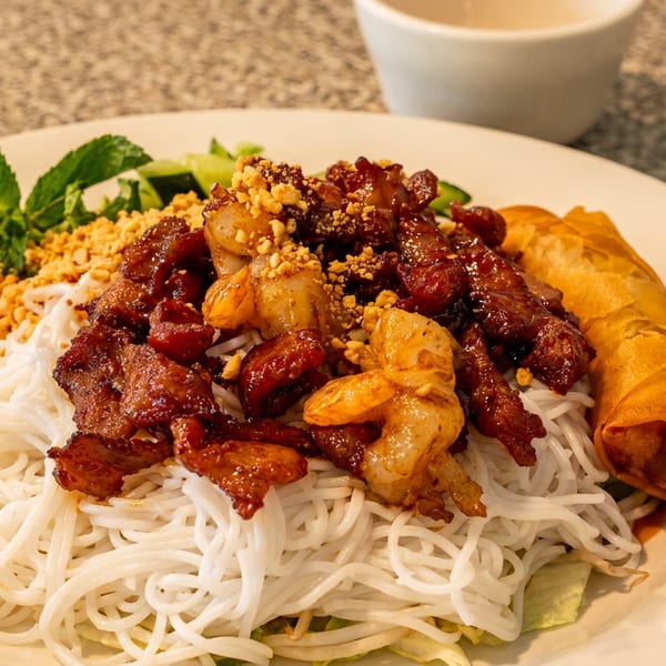 Vietnamese vermicelli noodles with grilled pork, shrimp, spring roll, peanuts, and fresh mint.